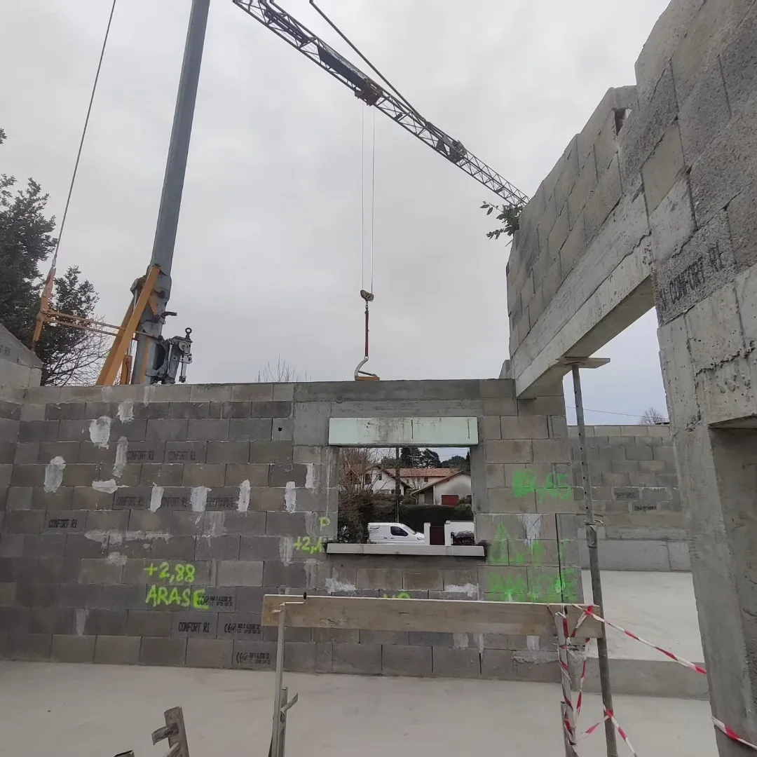 Reprise en blocs béton après démolition, linteau posé à la grue