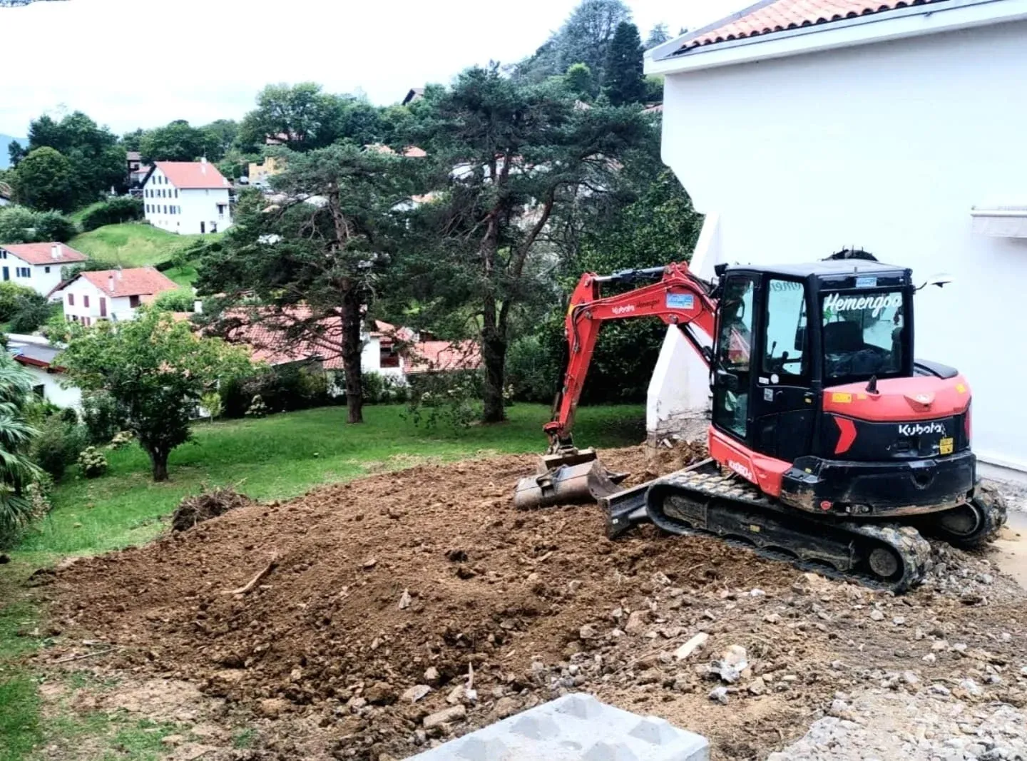 Pelle à chenilles travaillant dans un jardin, terres mises en tas